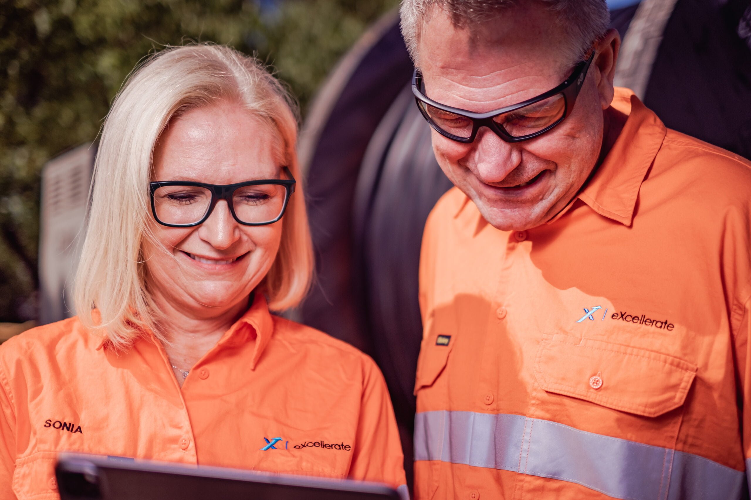 Mining supervisor and mining operator looking at a tablet screen.