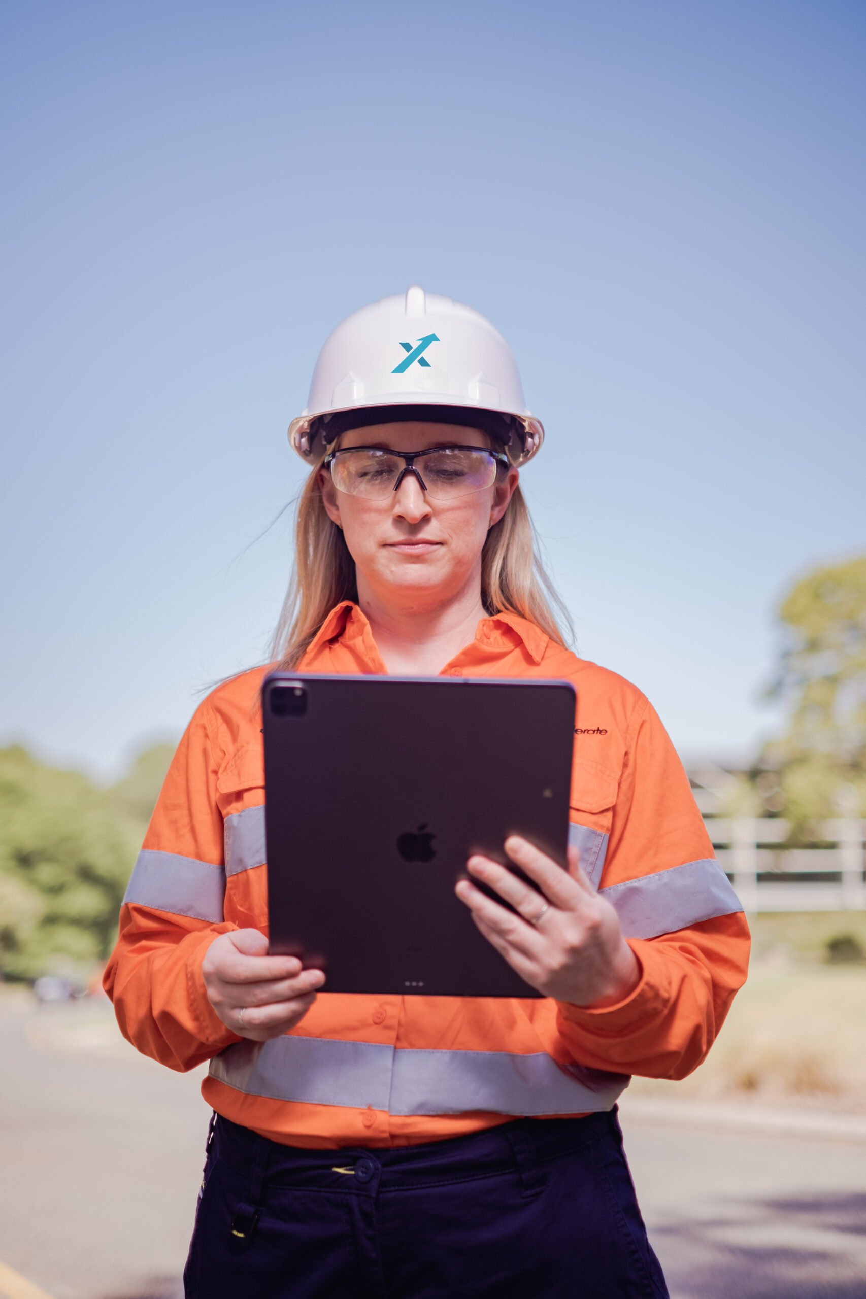 Female mining operator looking at tablet outside.