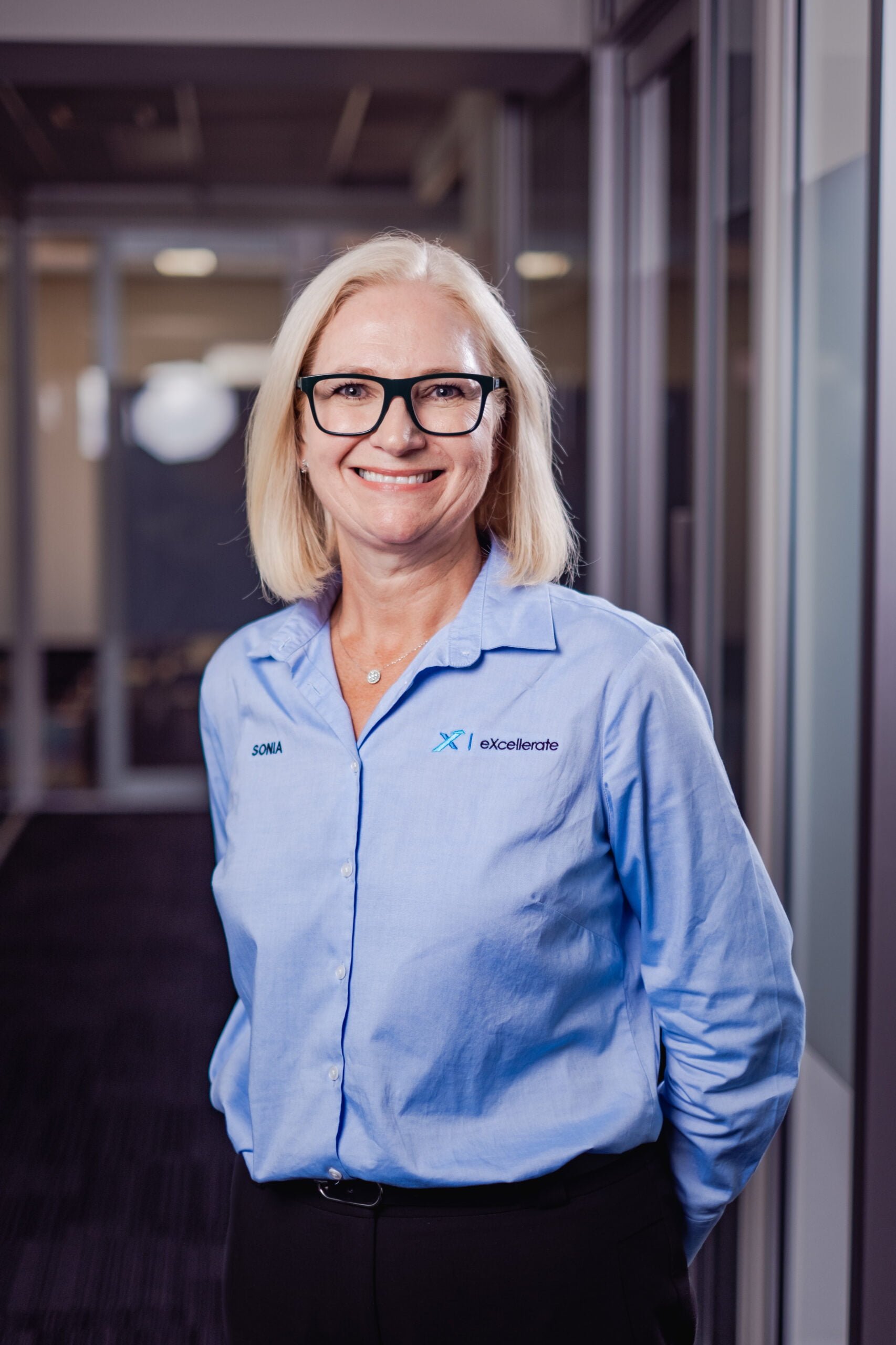 Picture of a women standing in an office with an eXcellerate shirt.